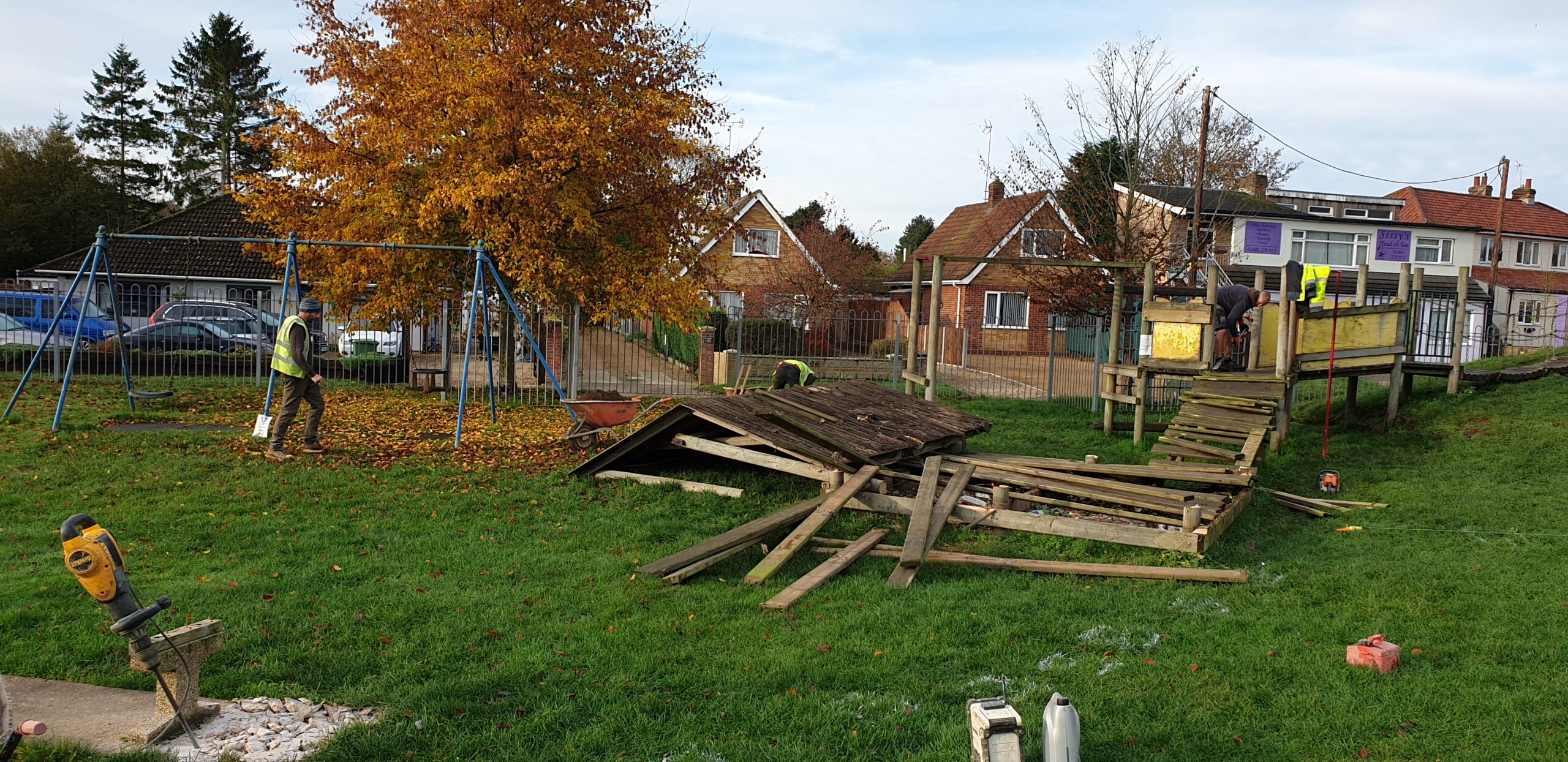 People dismantling the old wooden play area at Buxton village hall 